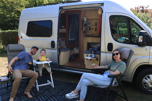 Lars, Tamara en Yara voor hun zelfgebouwde camper met zonnepanelen, klaar voor een off-grid avontuur dankzij Faraday Energy.