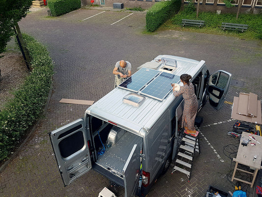 Serge en zijn vriendin installeren zonnepanelen op hun zelfbouwcamper bij Faraday Energy — voorbereiding voor 4.500 km off-grid reizen door Europa.
