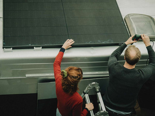 Peter van Faraday Energy installeert samen met Christa het zonnepaneel op hun Ford Transit camper als voorbereiding op hun Pan-Amerika reis.