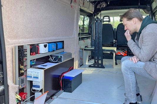 Niels bekijkt de voorgemonteerde camper-elektra van Faraday Energy in zijn Fiat Ducato, voorzien van lithium-accu en zonnepanelen op het hefdak.