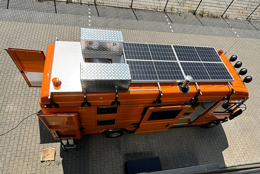 Oranje camper met groot zonnepanelensysteem voor off-grid reizen naar Noorwegen
