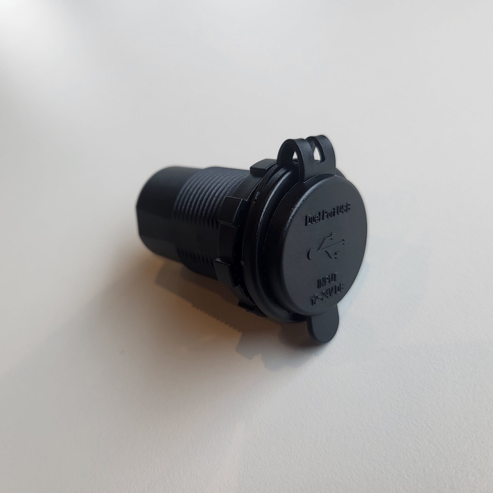 USB-inbouwstopcontact met beschermkap gesloten over de poorten, gezien van linksvoor